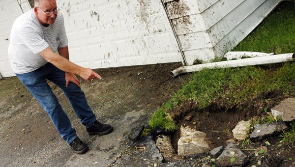 Craig Kizer points out a hole in his driveway he believes was created by a lightning strike. Leader photo/CRAIG HAUPERT 