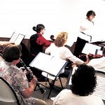 Valerie Rumpf conducts the orchestra during one of its Sunday afternoon rehearsals.