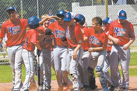 The Howard Township Red squad celebrates a home run on its mark to its fifth consecutive state tournament finals. (Leader photo/KELLY SWEENEY)