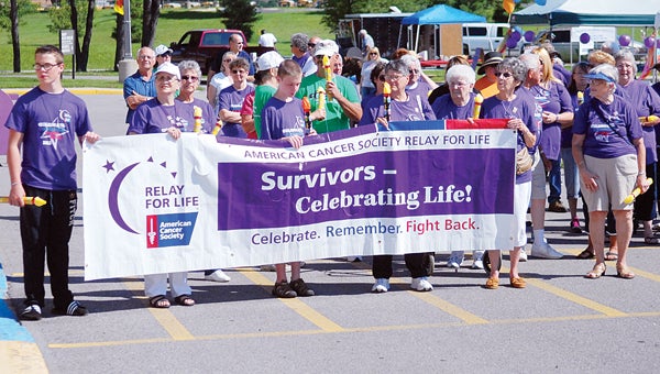The “Survivor’s Lap” kicked off the 2013 Edwardsburg Relay for Life at the Edwardsburg Middle School Saturday. At left, upon completion of the lap, survivors placed their candles on a came designed to show how long each one of them had been beating cancer. (Leader photo/SCOTT NOVAK)