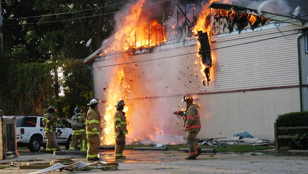 Pieces of flaming roof collapse as firefighters work to put out the blaze Wednesday. Leader photo/CRAIG HAUPERT