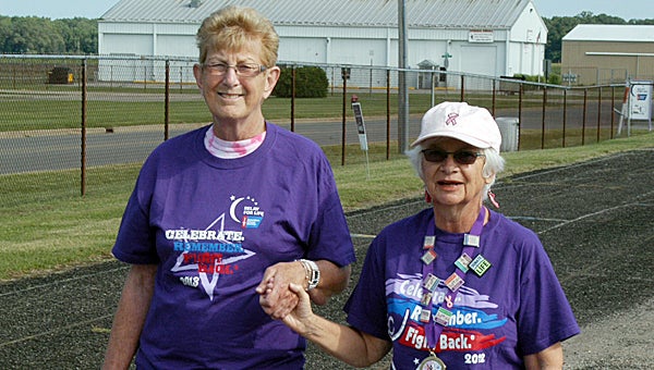 Kathy Casey and Betty McWilliams take part in Saturday’s Relay for Life survivors lap at APEX behind Union High, where Casey, a seven-year survivor, used to work in the guidance office. McWilliams underwent a heart transplant 24 years ago.
