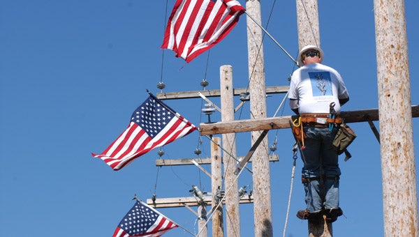 A LMC lineman school graduate works on hanging a crossbeam to a utility pole during a lineman rodeo Tuesday at LMC Bertrand Crossing. Leader photo/CRAIG HAUPERT