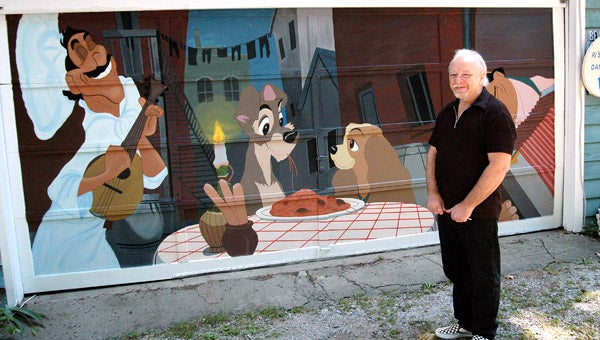 Robert Mitchell stands next to a mural he painted of the spaghetti scene from “Lady and the Tramp” on his garage in Niles. Leader photo/CRAIG HAUPERT