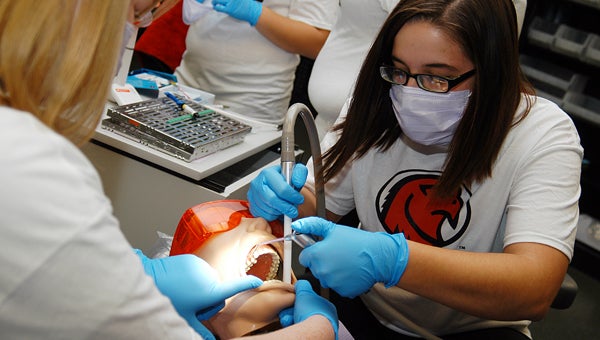 Emily Mokwa, right, and Colleen Norris, demonstrate what they are learning in Bertrand Crossing’s dental assistant program during an open house Wednesday at the campus. Leader photo/CRAIG HAUPERT