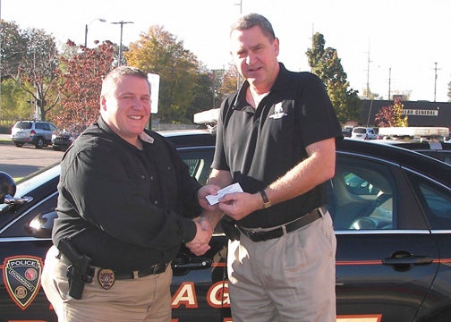 Provided Photo Steven Grinnewald, Dowagiac Director of Public Safety, purchases what he hopes to be a winning raffle ticket from Ray Klomes, member of Cass County Cancer Service. Provided Photo