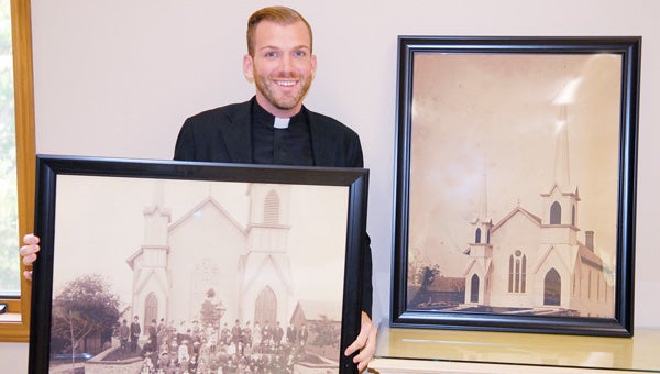 The Rev. Benjamin David Hutchison shows off historic photos of the Cassopolis United Methodist Church. The church will celebrate its 175th anniversary Sunday with a service and fellowship. (Leader photo/SCOTT NOVAK)