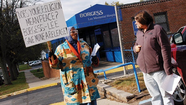 Cynthia King, left, talks to a passerby during a protest over alleged civil rights violations outside Borgess Lee Memorial Hospital Friday in Dowagiac. Leader photo/CRAIG HAUPERT