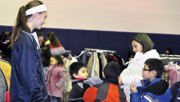 Niles varsity girls basketball member Kylee Myer helps local children pick out a warm coat. (Leader photo/Provided)